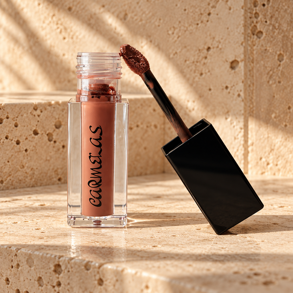Carmelas Rodeo Dust matte liquid lipstick in a beige vanity setting